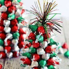 In the holiday spirit for a festive centerpiece, but aren't super crafty? These "Kiss"-mas Tree Centerpieces made with Hershey's Kisses are super easy to make and are a fun project to work on with kiddos!